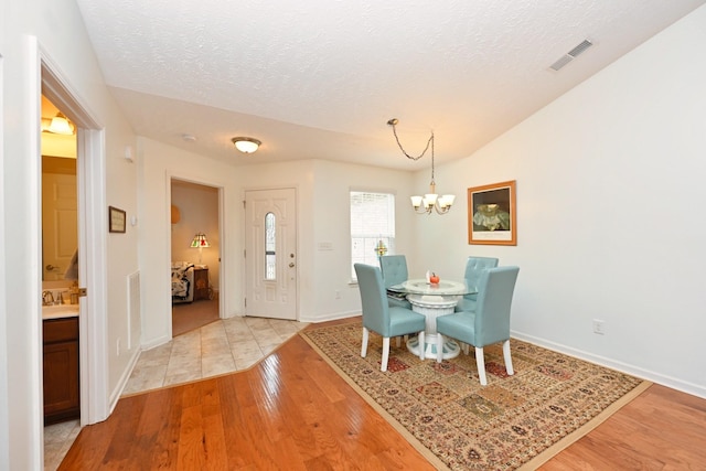395 Devon Chase Hl Unit 3602, Gallatin, TN 37066 - dining room with light wood finished floors, a chandelier, and a textured ceiling
