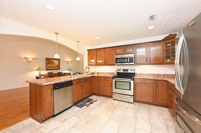 395 Devon Chase Hl Unit 3602, Gallatin, TN 37066 - kitchen featuring appliances with stainless steel finishes, a peninsula, lofted ceiling, brown cabinets, and recessed lighting