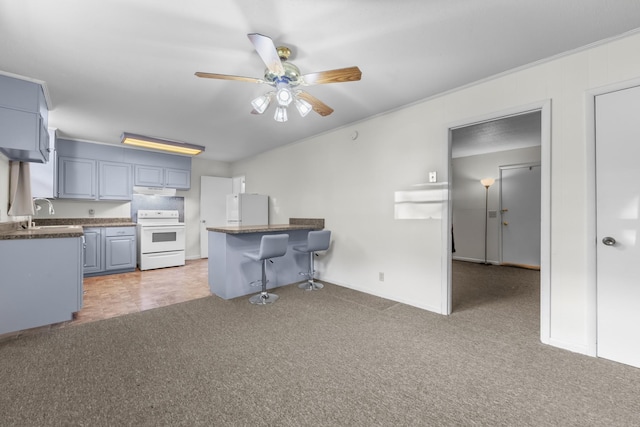3892 Cedar St, Centerville, TN 37033 - kitchen with white appliances, ceiling fan, light carpet, a peninsula, and a kitchen bar