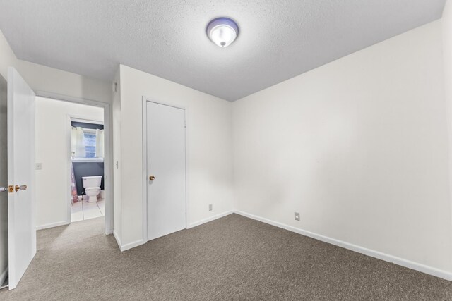 3892 Cedar St, Centerville, TN 37033 - unfurnished bedroom featuring dark carpet, a textured ceiling, and a closet