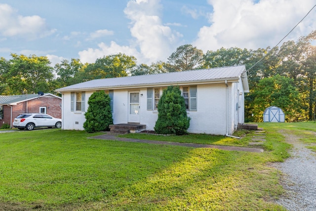 3892 Cedar St, Centerville, TN 37033 - view of front of home with a shed, a front yard, brick siding, and a metal roof