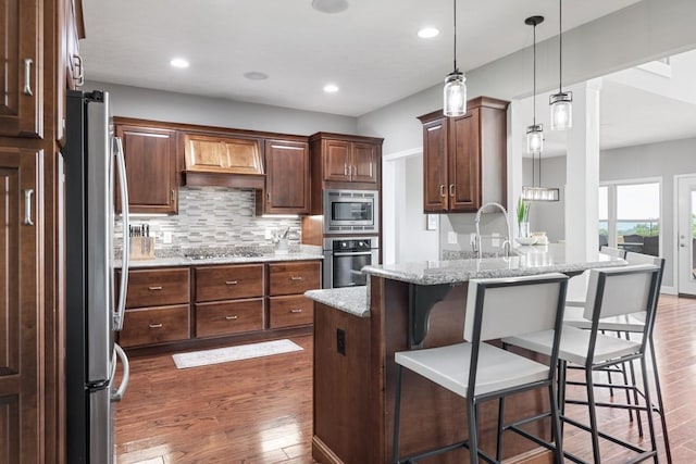 1250 Ed Seay Gregory Ln, Hartsville, TN 37074 - kitchen with stainless steel appliances, dark wood finished floors, a breakfast bar area, tasteful backsplash, and a peninsula