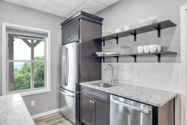 1250 Ed Seay Gregory Ln, Hartsville, TN 37074 - kitchen featuring appliances with stainless steel finishes, open shelves, backsplash, light wood-style floors, and light stone countertops