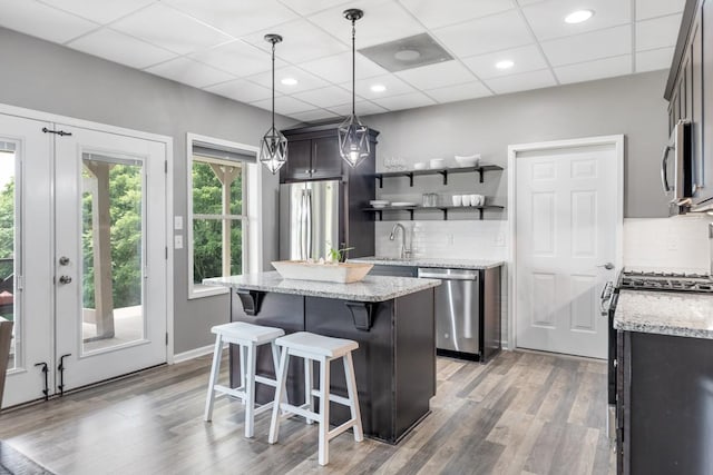 1250 Ed Seay Gregory Ln, Hartsville, TN 37074 - kitchen featuring appliances with stainless steel finishes, decorative backsplash, wood finished floors, a center island, and a drop ceiling
