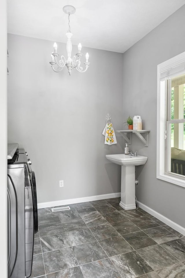 1250 Ed Seay Gregory Ln, Hartsville, TN 37074 - laundry area featuring washer and dryer, a chandelier, and dark stone finish floors