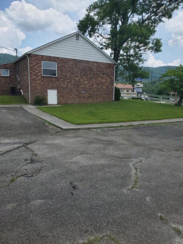 1171 5th St, Jellico, TN 37762 - view of side of home with brick siding and a yard