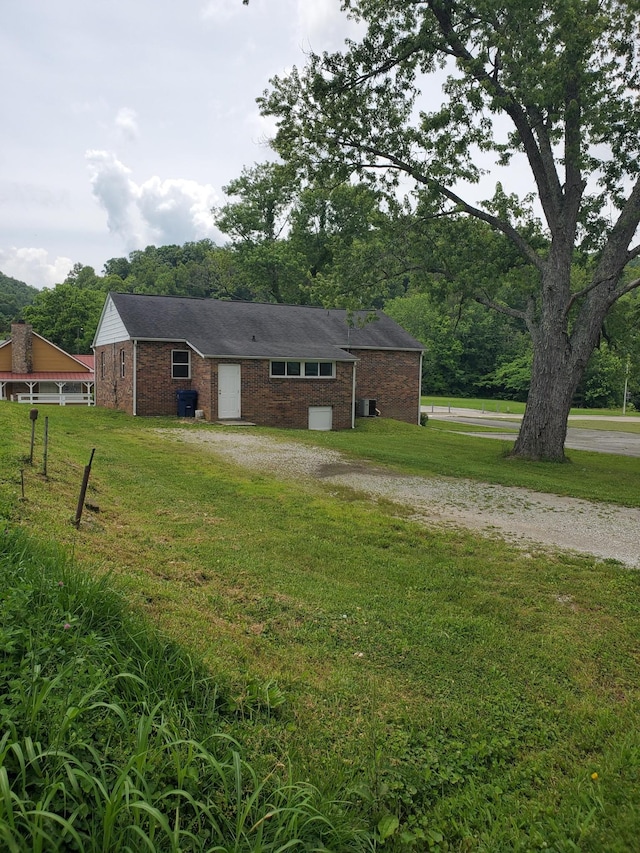1171 5th St, Jellico, TN 37762 - view of front facade with gravel driveway, a front lawn, and brick siding