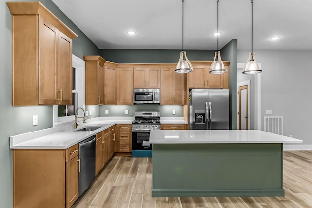 4106 Asbury Rd, Manchester, TN 37355 - kitchen featuring stainless steel appliances, light wood finished floors, light countertops, a center island, and pendant lighting