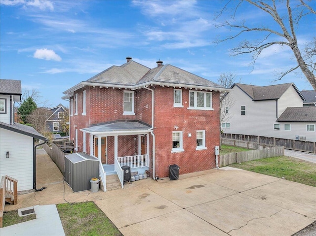 709 S Greenwood Ave S, Chattanooga, TN 37404 - rear view of property featuring brick siding, a fenced backyard, covered porch, and a chimney