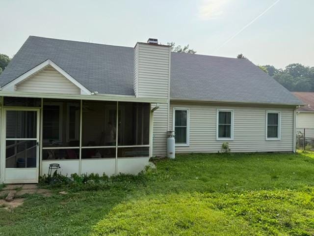 3367 Clearwater Dr, Clarksville, TN 37042 - rear view of house featuring a sunroom, a chimney, a lawn, and roof with shingles