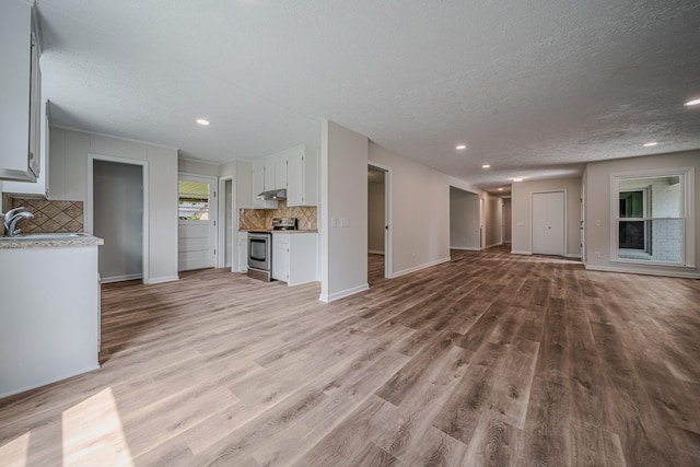 205 Walnut St, Smyrna, TN 37167 - unfurnished living room with light wood-style flooring, a textured ceiling, and recessed lighting