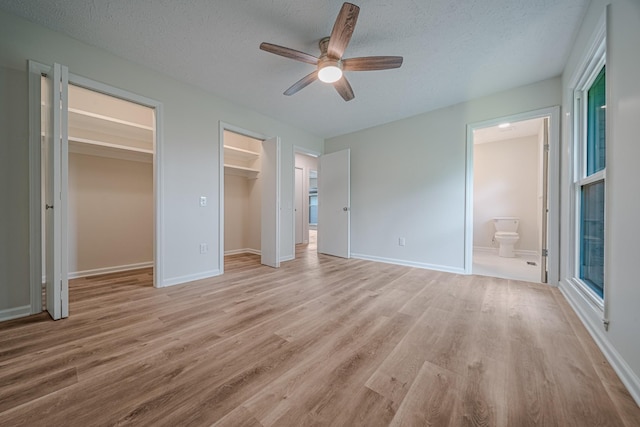 205 Walnut St, Smyrna, TN 37167 - unfurnished bedroom featuring light wood-style flooring, a textured ceiling, connected bathroom, a ceiling fan, and a spacious closet