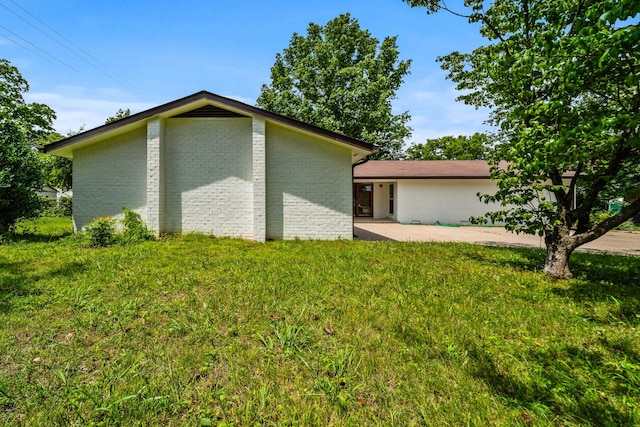 205 Walnut St, Smyrna, TN 37167 - view of home's exterior with a patio area, a lawn, and brick siding