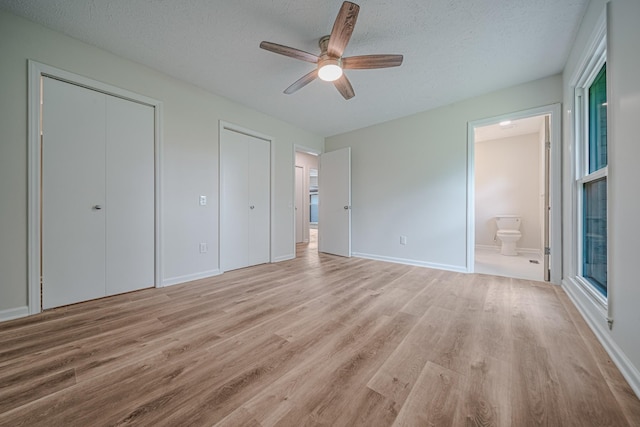 205 Walnut St, Smyrna, TN 37167 - unfurnished bedroom featuring light wood-type flooring, multiple closets, a textured ceiling, ensuite bathroom, and ceiling fan