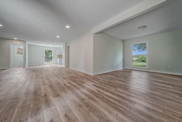 205 Walnut St, Smyrna, TN 37167 - unfurnished living room with light wood-style flooring, plenty of natural light, a textured ceiling, and recessed lighting