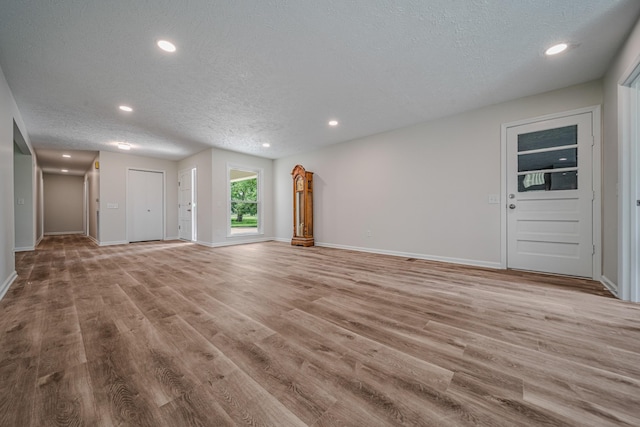 205 Walnut St, Smyrna, TN 37167 - unfurnished living room featuring a textured ceiling, light wood-style floors, and recessed lighting