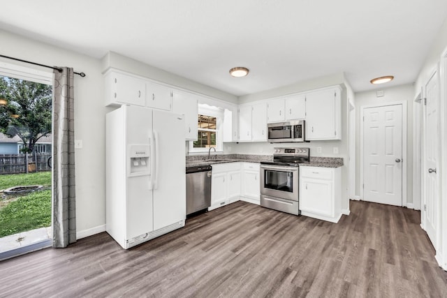 3405 Polly Dr, Clarksville, TN 37042 - kitchen featuring appliances with stainless steel finishes, dark wood-style flooring, healthy amount of natural light, and white cabinetry