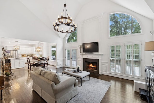 1060 Wilshire Way, Brentwood, TN 37027 - living area with a chandelier, high vaulted ceiling, dark wood-style flooring, and a warm lit fireplace