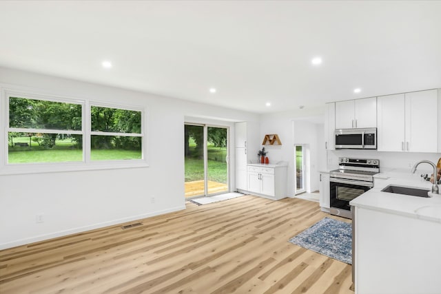 107 Hillsdale Dr, Hendersonville, TN 37075 - kitchen with stainless steel appliances, recessed lighting, light wood finished floors, white cabinets, and light stone counters
