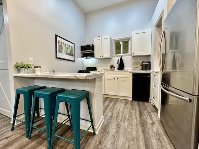 1307 Tomahawk Trce, Murfreesboro, TN 37129 - kitchen with stainless steel appliances, light wood-style floors, a breakfast bar area, and white cabinetry