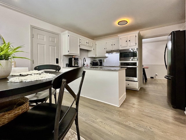1307 Tomahawk Trce, Murfreesboro, TN 37129 - kitchen featuring stainless steel appliances, ornamental molding, white cabinets, light wood-type flooring, and backsplash