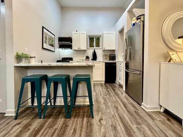 1307 Tomahawk Trce, Murfreesboro, TN 37129 - kitchen with freestanding refrigerator, wood finished floors, white cabinets, a kitchen breakfast bar, and a peninsula