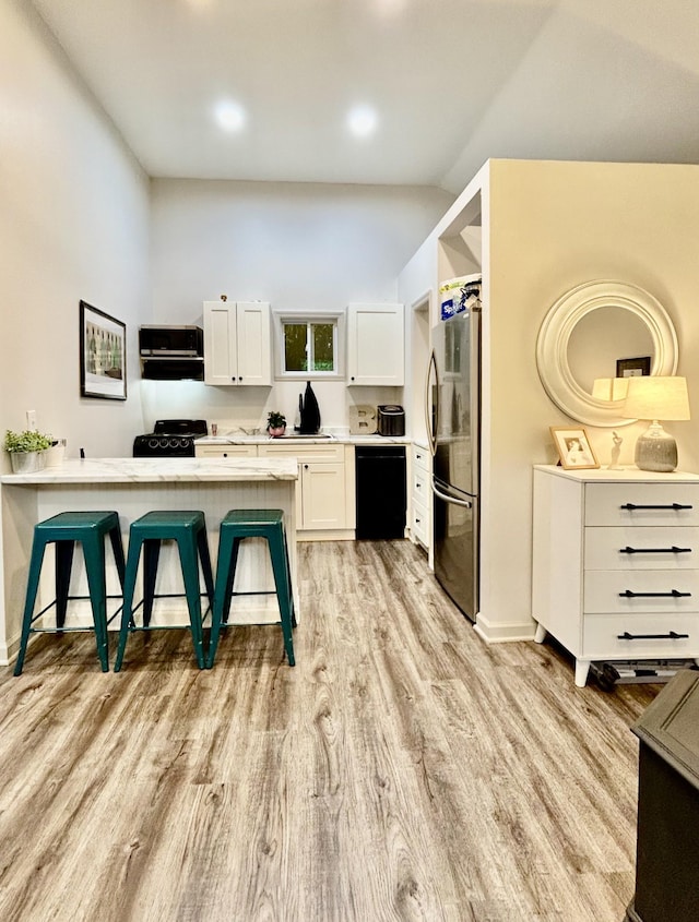 1307 Tomahawk Trce, Murfreesboro, TN 37129 - kitchen featuring dishwasher, freestanding refrigerator, a kitchen bar, light wood finished floors, and white cabinetry