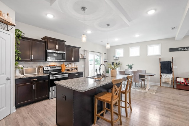 1098 Eagles View Dr, Clarksville, TN 37040 - kitchen featuring appliances with stainless steel finishes, a breakfast bar area, plenty of natural light, light wood finished floors, and recessed lighting