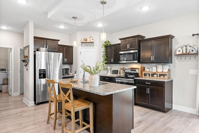 1098 Eagles View Dr, Clarksville, TN 37040 - kitchen featuring appliances with stainless steel finishes, dark brown cabinets, light wood-style flooring, decorative backsplash, and recessed lighting