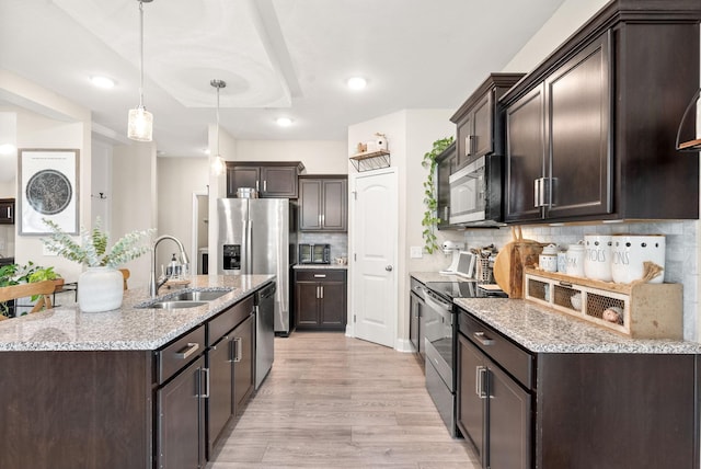 1098 Eagles View Dr, Clarksville, TN 37040 - kitchen featuring appliances with stainless steel finishes, dark brown cabinets, light wood-style flooring, decorative backsplash, and recessed lighting