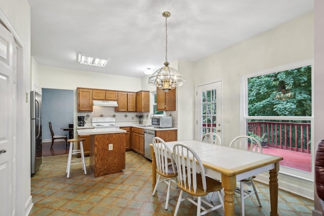 1438 Brighton Cir, Old Hickory, TN 37138 - kitchen with stainless steel appliances, under cabinet range hood, brown cabinets, a center island, and light flooring
