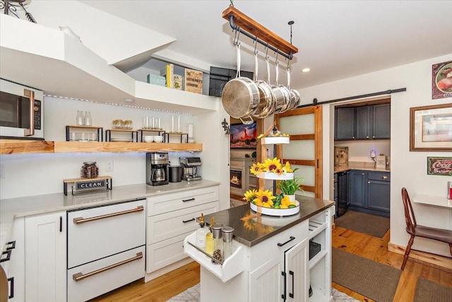 145 W Hollis Chapel Rd, Portland, TN 37148 - kitchen with open shelves, a barn door, light wood finished floors, white cabinets, and recessed lighting