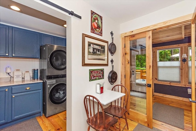 145 W Hollis Chapel Rd, Portland, TN 37148 - laundry area featuring stacked washer / drying machine, light wood-style flooring, and a barn door