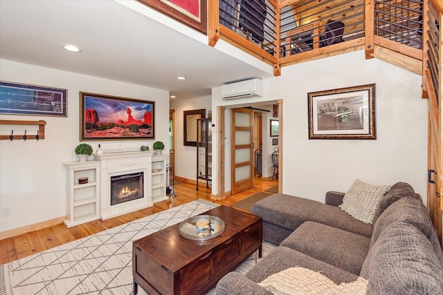 145 W Hollis Chapel Rd, Portland, TN 37148 - living room with an AC wall unit, wood finished floors, a warm lit fireplace, and recessed lighting