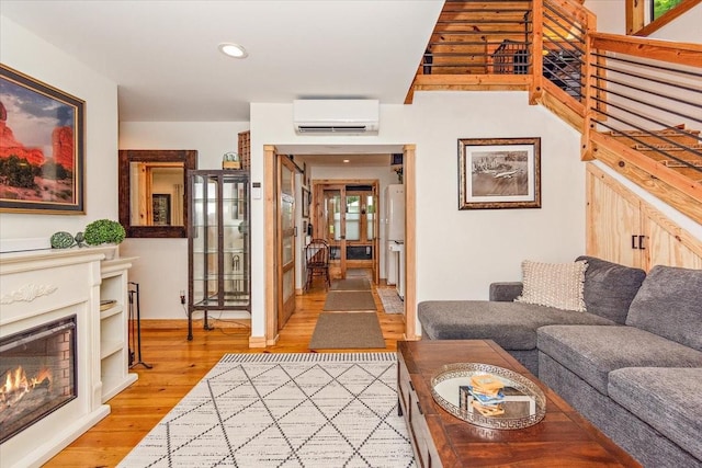 145 W Hollis Chapel Rd, Portland, TN 37148 - living room featuring an AC wall unit, light wood-style floors, recessed lighting, and a lit fireplace