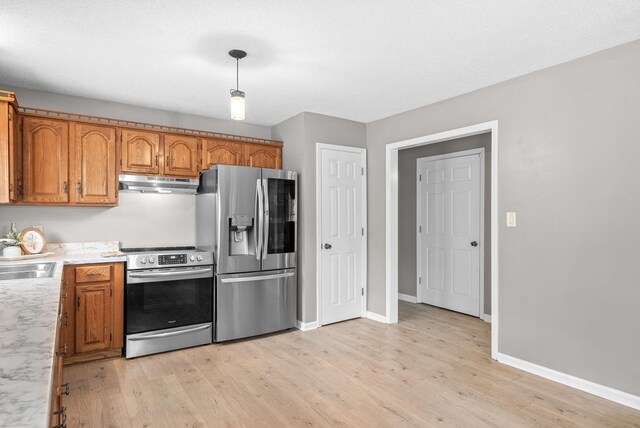 2430 Underwood Rd, Cunningham, TN 37052 - kitchen with appliances with stainless steel finishes, under cabinet range hood, light countertops, and brown cabinetry