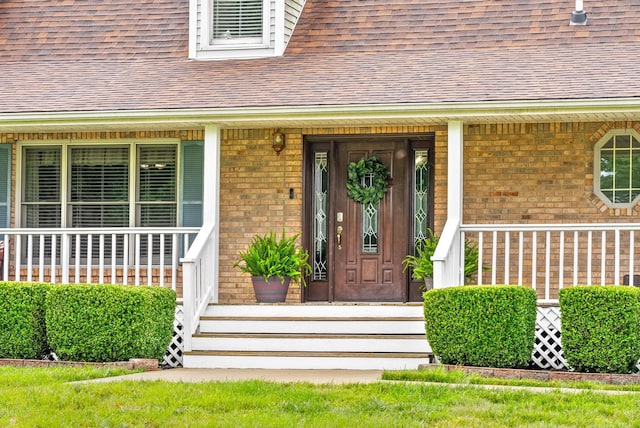 2430 Underwood Rd, Cunningham, TN 37052 - doorway to property featuring brick siding, a shingled roof, and covered porch