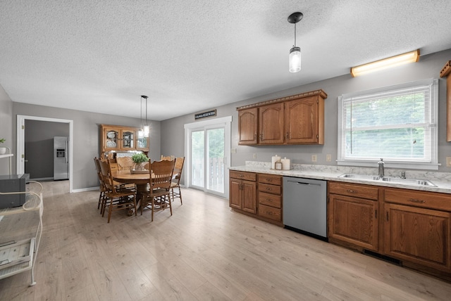 2430 Underwood Rd, Cunningham, TN 37052 - kitchen featuring stainless steel appliances, a textured ceiling, brown cabinetry, light countertops, and light wood finished floors