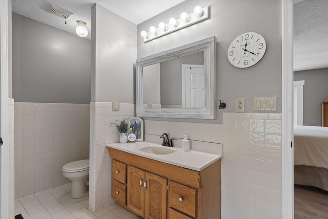 2430 Underwood Rd, Cunningham, TN 37052 - bathroom with tile walls, a textured ceiling, ensuite bathroom, vanity, and a wainscoted wall