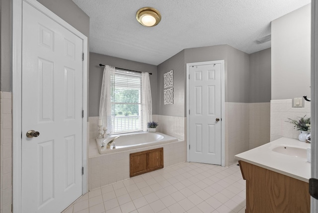 2430 Underwood Rd, Cunningham, TN 37052 - full bathroom featuring a garden tub, tile patterned flooring, vanity, wainscoting, and a textured ceiling