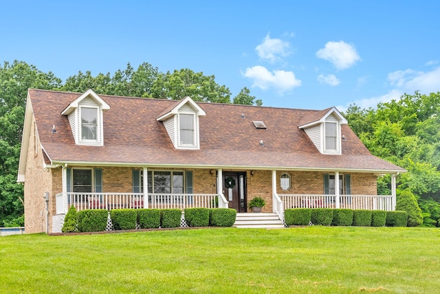 2430 Underwood Rd, Cunningham, TN 37052 - cape cod home featuring brick siding, a porch, a front yard, and roof with shingles