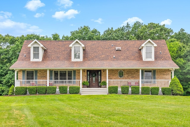 2430 Underwood Rd, Cunningham, TN 37052 - cape cod house with brick siding, a porch, a front yard, and roof with shingles