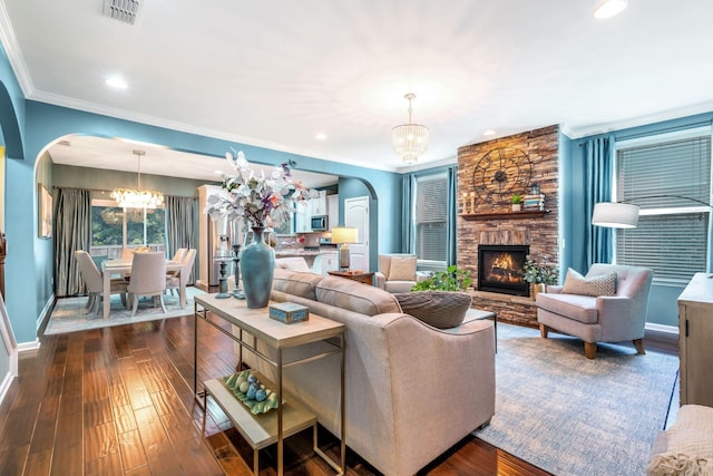 625 Foster Ln, Mount Juliet, TN 37122 - living area featuring arched walkways, a chandelier, a fireplace, ornamental molding, and dark wood finished floors