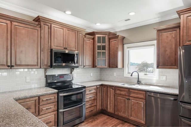 133 Tanasi Shr, Gallatin, TN 37066 - kitchen featuring stainless steel appliances, wood finished floors, light stone counters, glass insert cabinets, and crown molding