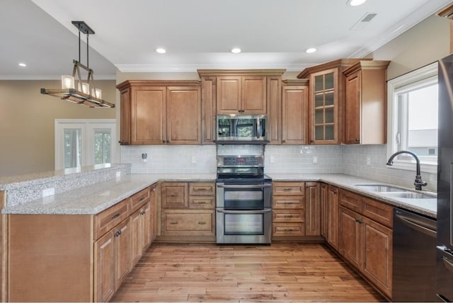 133 Tanasi Shr, Gallatin, TN 37066 - kitchen with stainless steel appliances, ornamental molding, a peninsula, brown cabinets, and light stone countertops