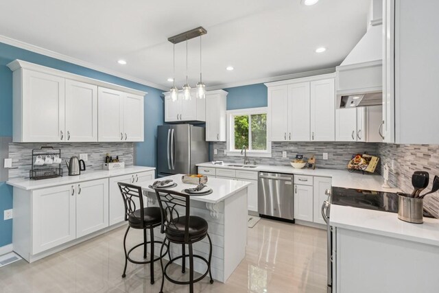 148 Quita Cir, Lebanon, TN 37087 - kitchen with appliances with stainless steel finishes, backsplash, ornamental molding, white cabinetry, and a kitchen breakfast bar