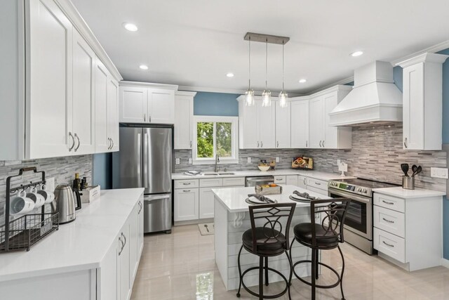 148 Quita Cir, Lebanon, TN 37087 - kitchen with appliances with stainless steel finishes, custom range hood, a kitchen breakfast bar, backsplash, and recessed lighting
