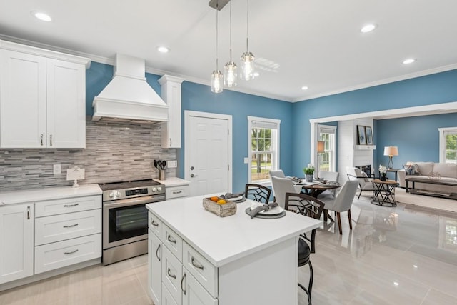 148 Quita Cir, Lebanon, TN 37087 - kitchen with premium range hood, stainless steel electric range, light countertops, decorative backsplash, and a kitchen island