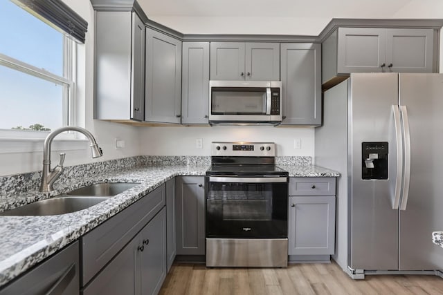 1202 Oak Grove Rd, Dickson, TN 37055 - kitchen featuring appliances with stainless steel finishes, gray cabinets, light wood-style floors, and light stone counters