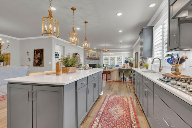 3002 Obion Pass, Spring Hill, TN 37174 - kitchen featuring gray cabinets, a chandelier, open floor plan, light wood finished floors, and crown molding